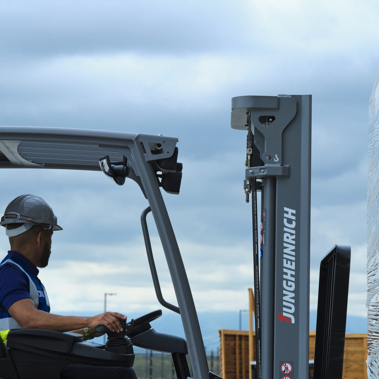 A forklift operator at work, seated in the driver's compartment of a forklift